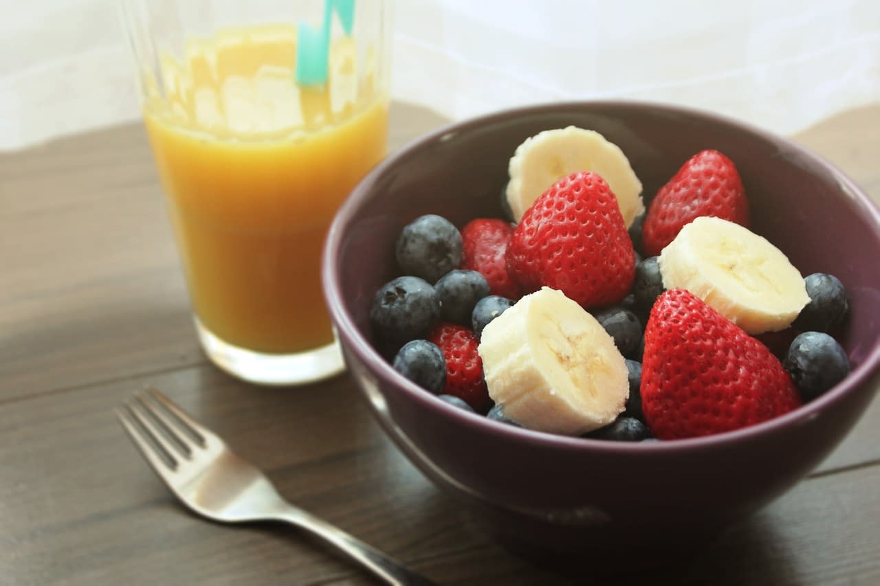 A bowl full of pre-workout fruits and orange juice